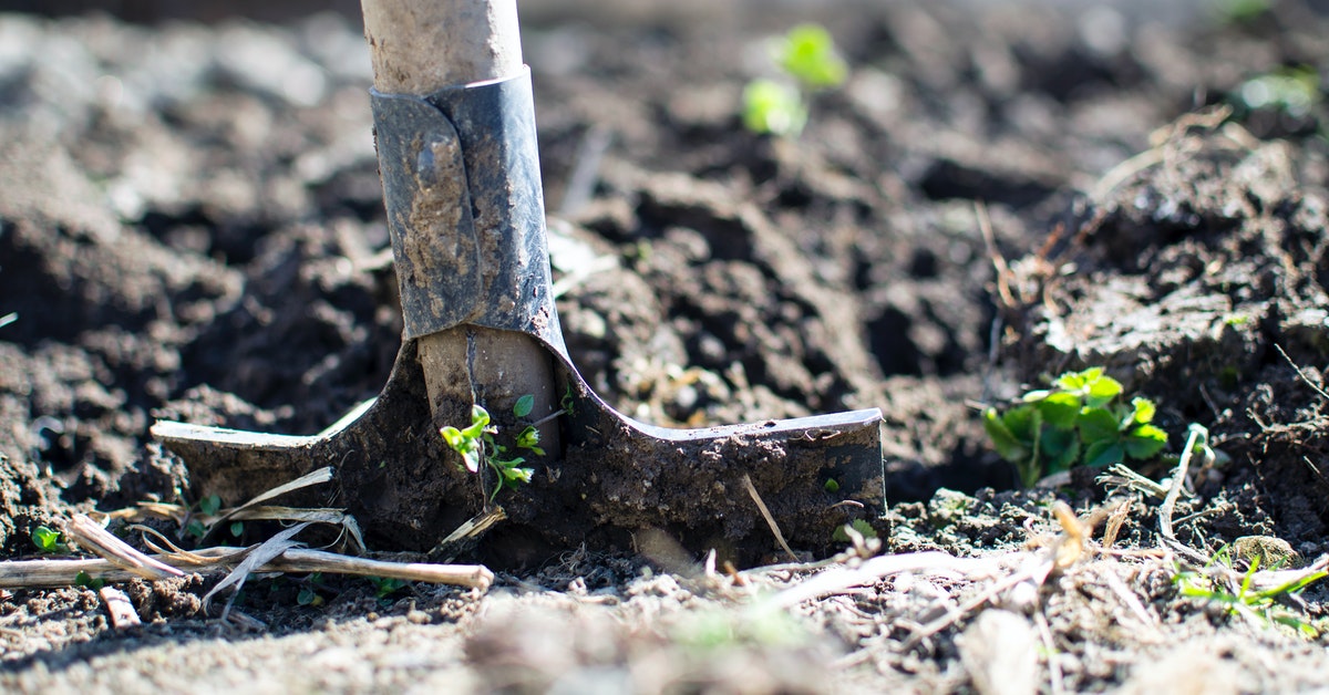 A shovel digging into soil