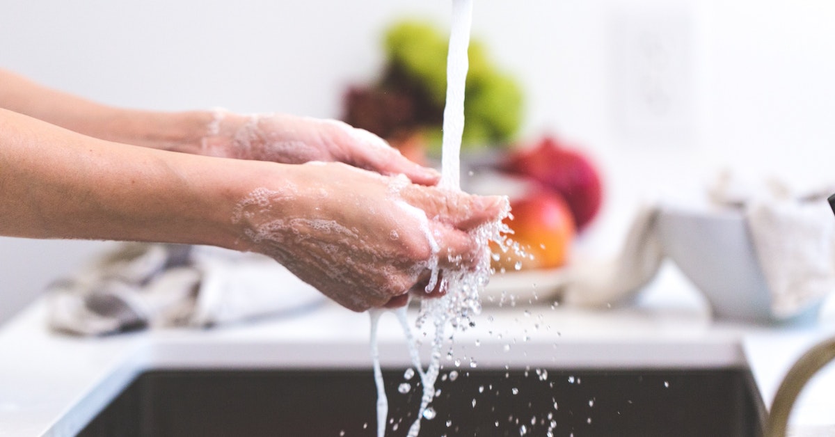 Someone washing their hands in a kitchen