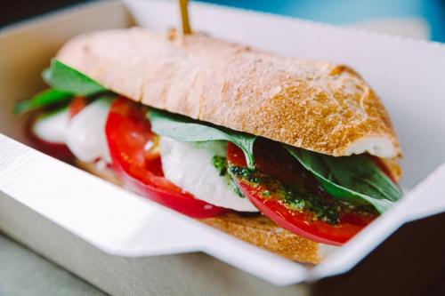 A vegetarian sandwich in a takeout container